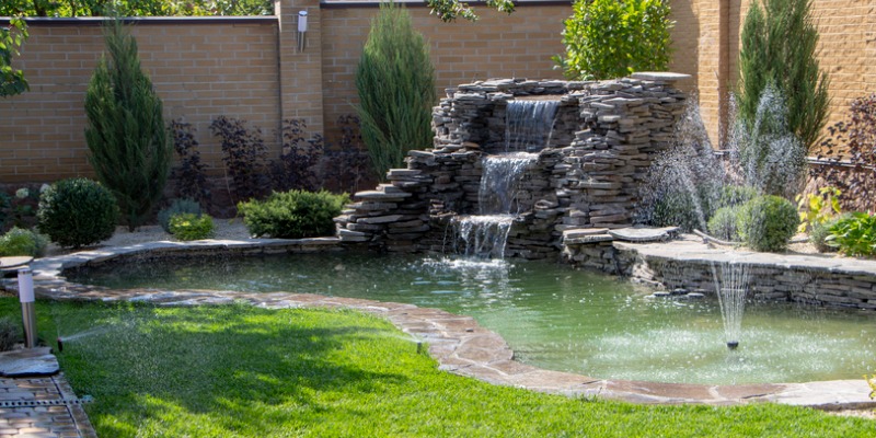 Waterfall in backyard - The Best Water Features to Build with Ledgestone